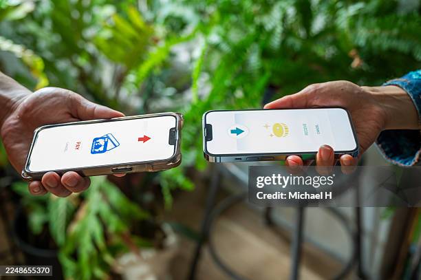 mobile payment transfer between two hands using smart phones - contactless delivery stock pictures, royalty-free photos & images