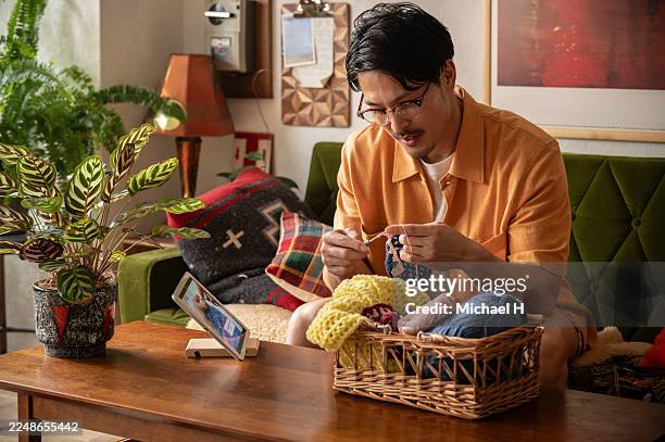 man crocheting at home while watching a tutorial on a tablet - knitting stock pictures, royalty-free photos & images