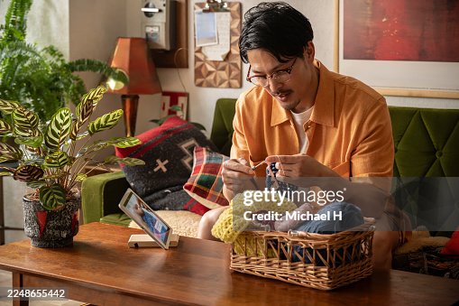 Man Crocheting at Home While Watching a Tutorial on a Tablet Man Crocheting at Home While Watching a Tutorial on a Tablet