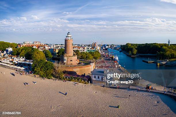 urlaub in polen – luftaufnahme vom strand und leuchtturm mit dem hafen in kolobrzeg, einem kurort im westpommern, - woiwodschaft westpommern stock-fotos und bilder
