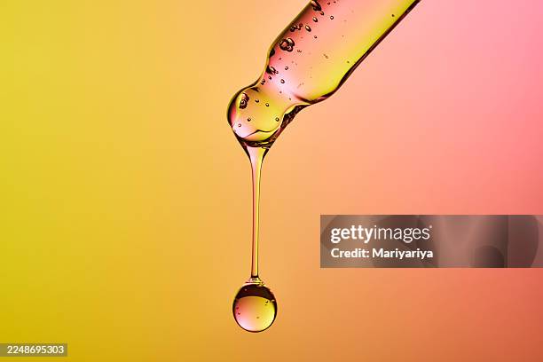dropper releasing serum drop for biotechnology skincare research - facial oil stock pictures, royalty-free photos & images