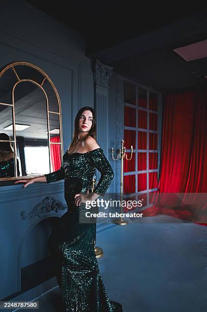 frau posiert in einem eleganten grünen paillettenkleid - paillettenkleid stock-fotos und bilder