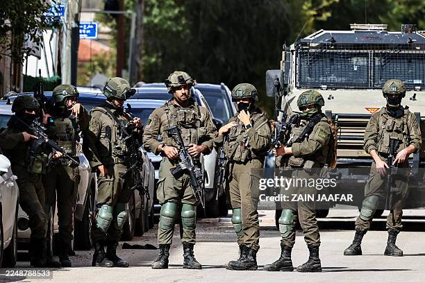 Israeli soldiers take positions during a raid in Ramallah, in the occupied West Bank on December 1, 2025.