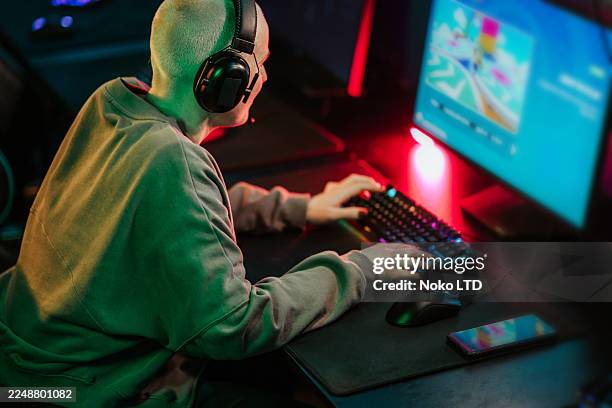person playing computer video game wearing headset - gaming station stock pictures, royalty-free photos & images