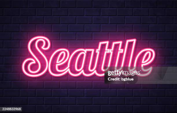 seattle - glowing neon text on brick wall background - seattle stock illustrations