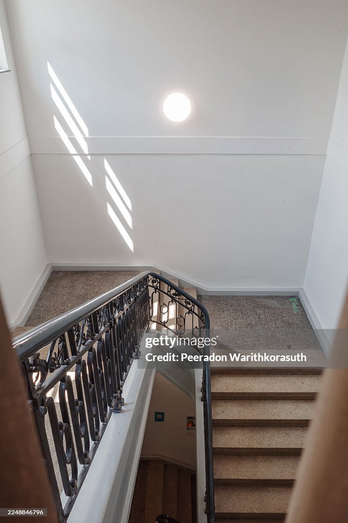 Astone staircase featuring an ornate black metal railing,