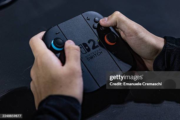 Gamers uses the Joy-Con 2 game controller for Nintendo Switch 2 as he plays video games at the Japanese publisher Nintendo Switch's stand during...