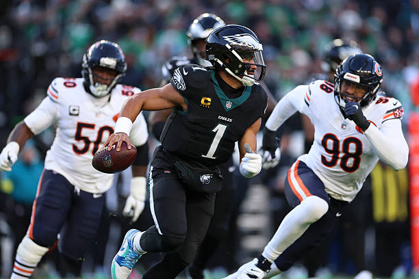 Jalen Hurts of the Philadelphia Eagles rolls out to throw a pass during the first quarter of an NFL football game against the Chicago Bears at...