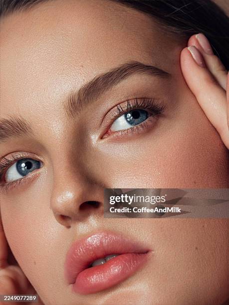 nahaufnahme einer frau mit blauen augen und weicher haut, die natürliche schönheit zeigt - augenbraue stock-fotos und bilder