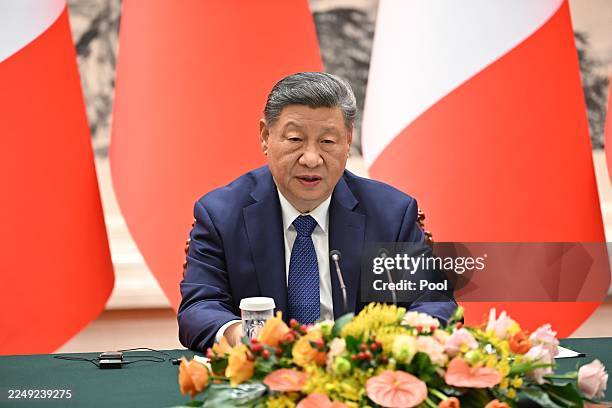 China's President Xi Jinping speaks next to France's President Emmanuel Macron during a joint press conference at the Great Hall of the People on...