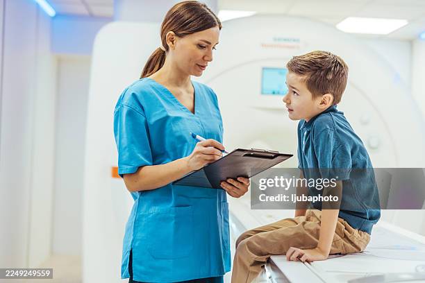 krankenschwester und junge patientin diskutieren medizinische informationen im krankenhaus - fairness stock-fotos und bilder