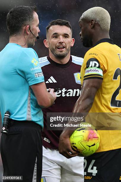 Referee Chris Kavanagh addresses captains John McGinn of Aston Villa and Toti of Wolverhampton Wanderers during the Premier League match between...