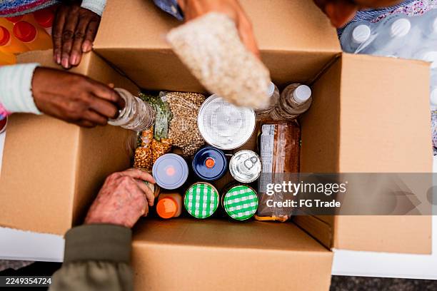 volunteers packing food donation box - banco alimentar imagens e fotografias de stock