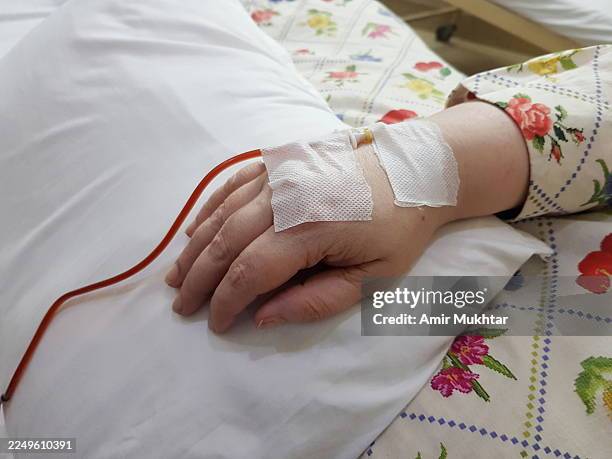 intravenous iron drip directly into a woman patient's bloodstream through a vein to treat low iron levels and iron deficiency anemia. - iron deficiency anemia stock pictures, royalty-free photos & images