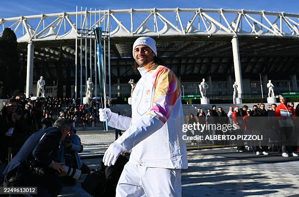 Italy's high jump athlete and torchbearer Gianmarco Tamberi holds the torch at the Stadio dei Marmi one of four stadiums located in the Foro Italico...