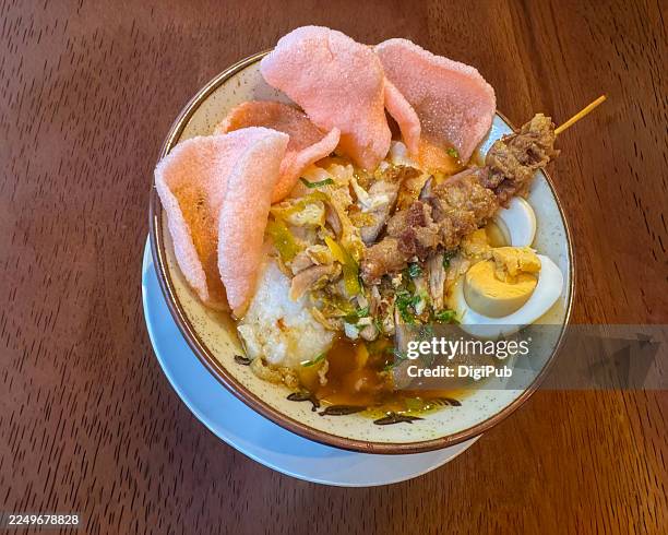 bubur ayam (indonesian turmeric chicken porridge) with savory toppings - porcelain stock pictures, royalty-free photos & images