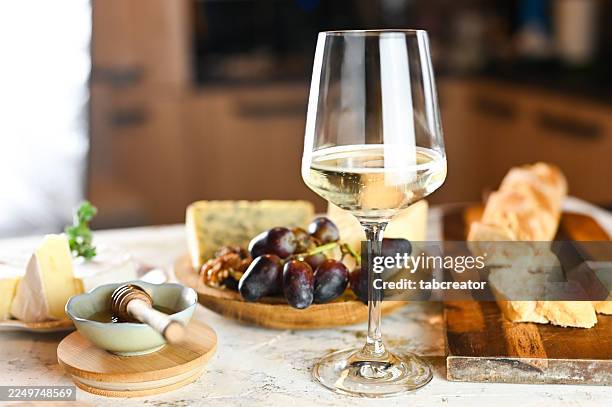 verre de vin blanc avec plateau de fromages et en-cas - vin blanc photos et images de collection