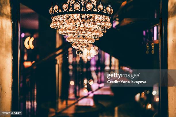 elegant crystal chandelier close up with warm glow and sparkling beads, creating luxurious ambiance for upscale interiors and sophisticated events - ambient light stock pictures, royalty-free photos & images