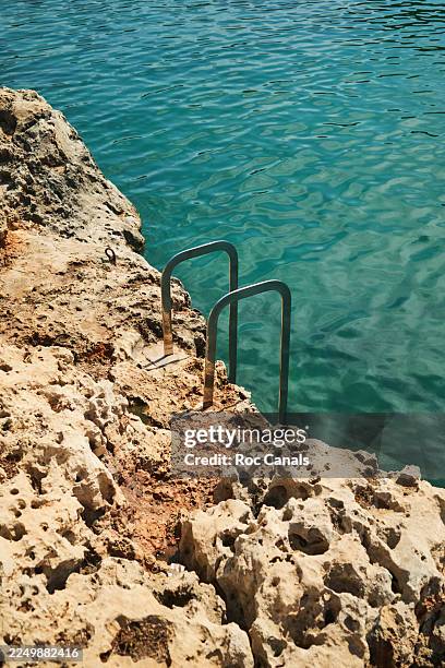metal ladder on rocks entering clear sea water - mediterranean sea stock pictures, royalty-free photos & images