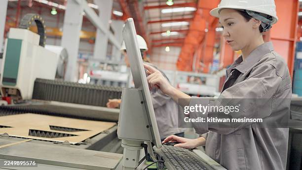 machine operator, skilled and experienced in safety gear, works on a metal processing production line, setting up and operating metal forming machinery. an female engineer or technician working in a factory in the manufacturing industry. - heavy machine operator stock pictures, royalty-free photos & images