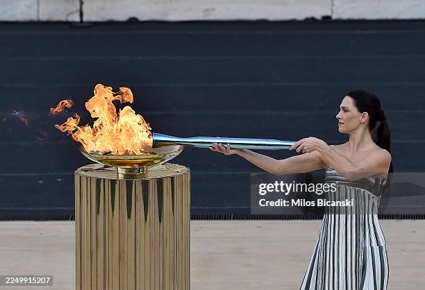 Actress Mary Mina lights the Olympic torch before presenting it to Isidoros Kouvelos, President of the Hellenic Olympic Committee, , during the...