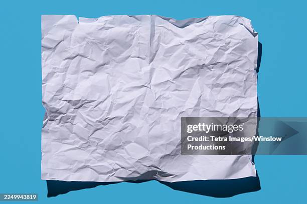 blank crumpled paper on blue background - crumpled paper stock pictures, royalty-free photos & images