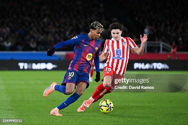 Lamine Yamal of FC Barcelona competes for the ball with Julian Alvarez of Atletico Madrid looks on during the LaLiga EA Sports match between FC...