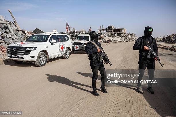 Palestinian Hamas militants secure the area as Egyptian workers accompanied by members of the International Committee of the Red Cross search for the...