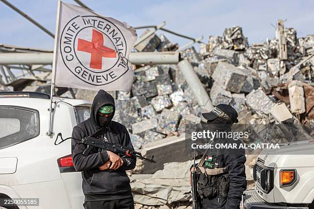 Palestinian Hamas militants secure the area as Egyptian workers accompanied by members of the International Committee of the Red Cross search for the...