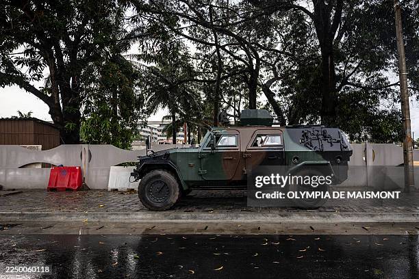 An aromoured vehicle is positioned at the entrance of a blocked road next to the National Television, Benin TV, in Cotonou, on December 08, 2025....