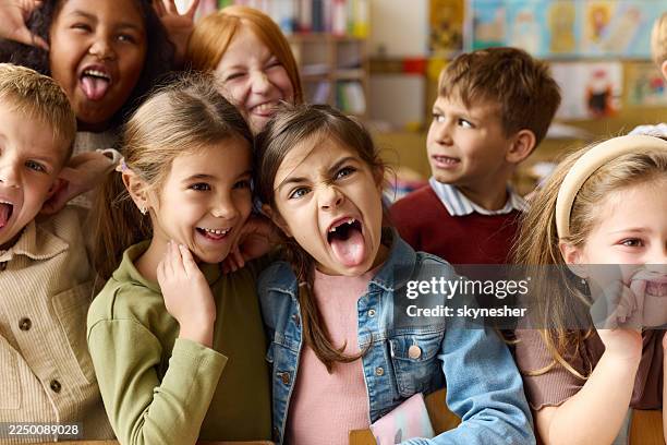playful school kids making faces in the classroom. - making a face stock pictures, royalty-free photos & images