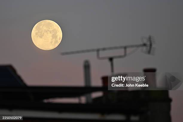 Full Cold moon, Supermoon is seen above a house with chimney pots and TV aerial in the early morning on December 5, 2025 in Leigh on Sea, United...