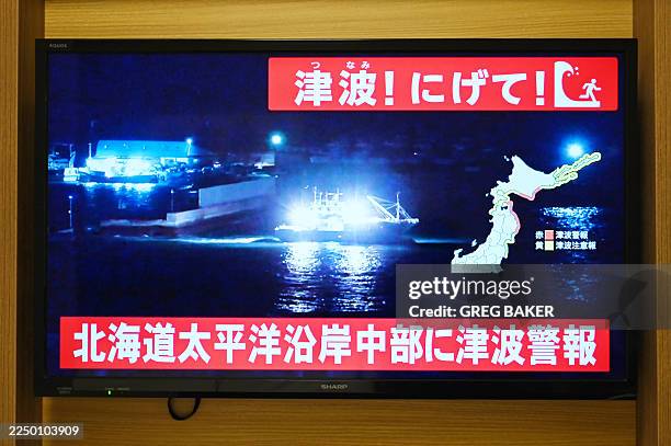 An advisory reading "Tsunami! Run!" and "Tsunami warning issued for central Hokkaido's Pacific Coast" flashes over the live footage of a boat leaving...