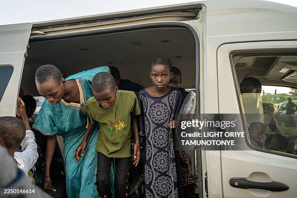 Schoolchildren leave a minibus as they arrive at the local Governor's office in Minna on December 8, 2025. Around a hundred schoolchildren who were...