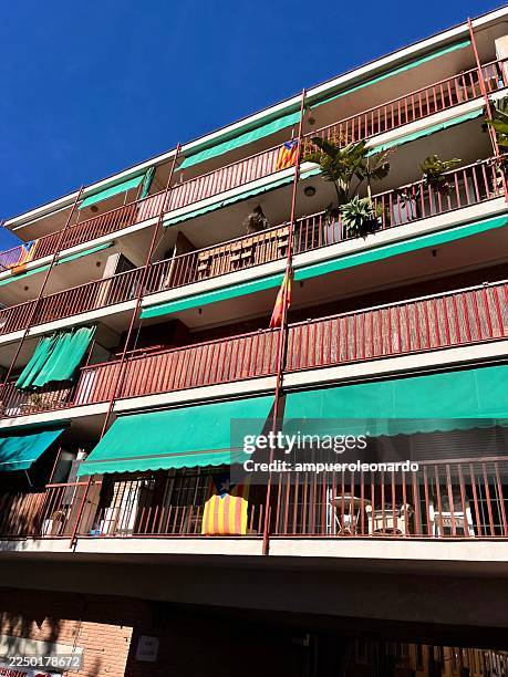 barcelona apartment building featuring spanish and catalan flags - awning stock pictures, royalty-free photos & images