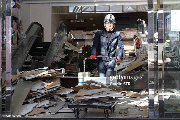 Worker clears debris at a shopping center damaged by the earthquake in Hachinohe City, Aomori Prefecture on December 9, 2025. A big quake off...