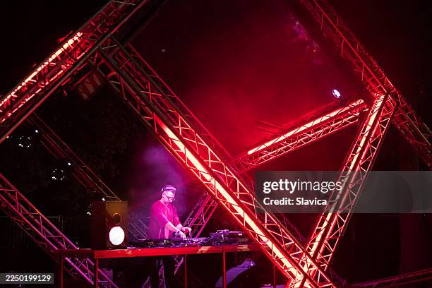 dj playing techno music on the futuristic stage - laser light show stock pictures, royalty-free photos & images