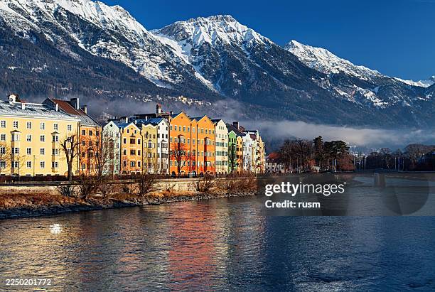 colourful houses on mariahilf street along the inn river at clear winter morning, innsbruck, austria - innsbruck stock pictures, royalty-free photos & images