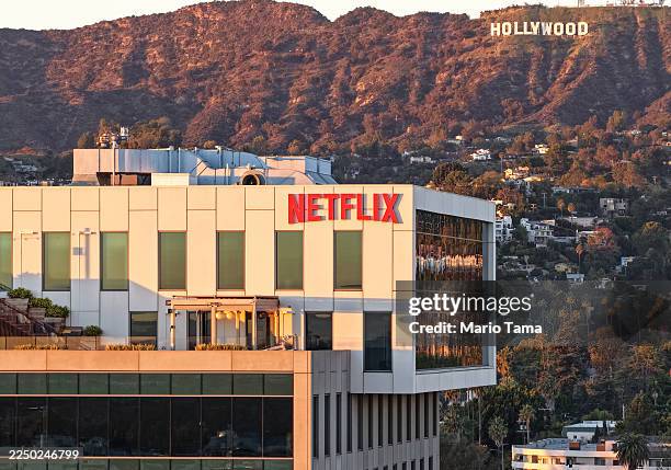 An aerial view of the Netflix logo displayed at Netflix studios, with the Hollywood sign in the distance, on December 5, 2025 in Los Angeles,...
