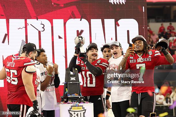 Jacob Rodriguez of the Texas Tech Red Raiders lifts the trophy and celebrates with teammates after defeating the BYU Cougars in the 2025 Edward Jones...
