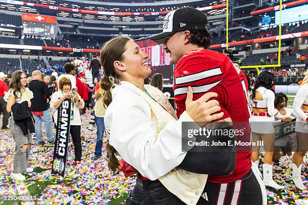 Jacob Rodriguez of the Texas Tech Red Raiders and his wife, Emma Rodriguez, embrace after the Big 12 Championship game against the BYU Cougars at...