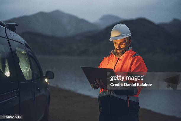 green energy. engineer using ai on laptop for dam optimization - reflective clothing stock pictures, royalty-free photos & images