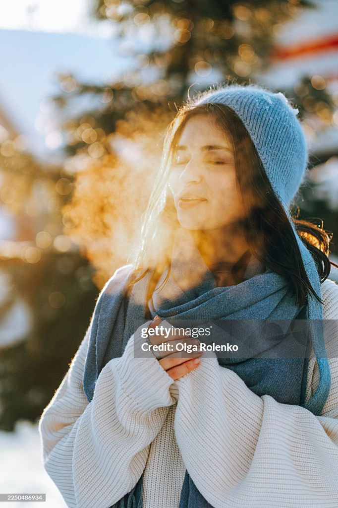 Woman breathing cold winter air with sunlight