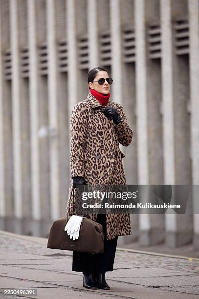 Gili Biegun wears leopard long coat by Baum und Pferdgarten, red knitted top, large Demellier London The Stockholm bag in Hazel suede with hanging...