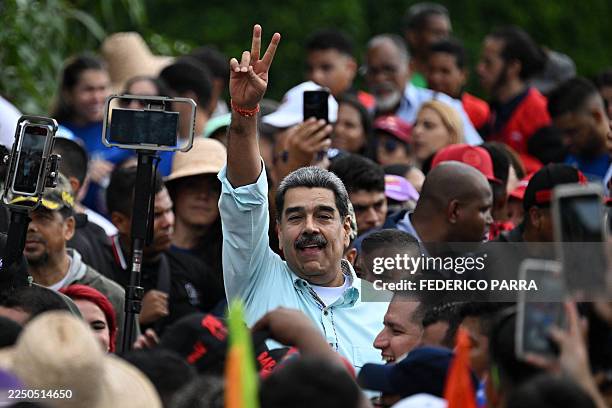 Venezuela's President Nicolas Maduro greets supporters upon his arrival at a rally marking the anniversary of the Battle of Santa Ines, in Caracas on...