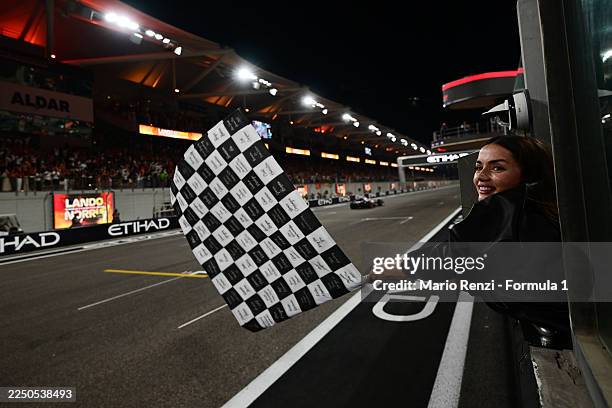 Ana de Armas waves the chequered flag during the F1 Grand Prix of Abu Dhabi at Yas Marina Circuit on December 07, 2025 in Abu Dhabi, United Arab...
