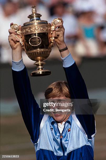 German tennis player Boris Becker celebrates with the men's singles trophy after the 99th Wimbledon Championships men's singles final at the All...