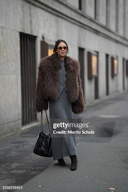 Patricia Wirschke is seen wearing a chocolate brown oversized faux fur Ducie jacket with a voluminous, fluffy texture and straight, hip-length...
