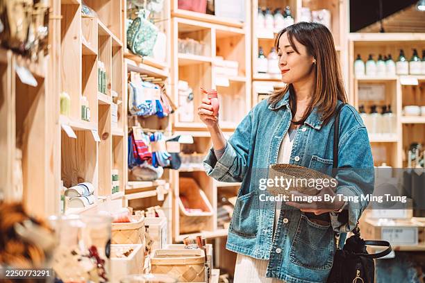 woman shopping for home and lifestyle products in a boutique store - gift shop stock pictures, royalty-free photos & images