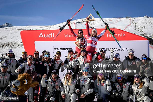 Second-placed Austria's Magdalena Egger and third-placed Austria's Mirjam Puchner celebrate with their team on the podium after competing in the...